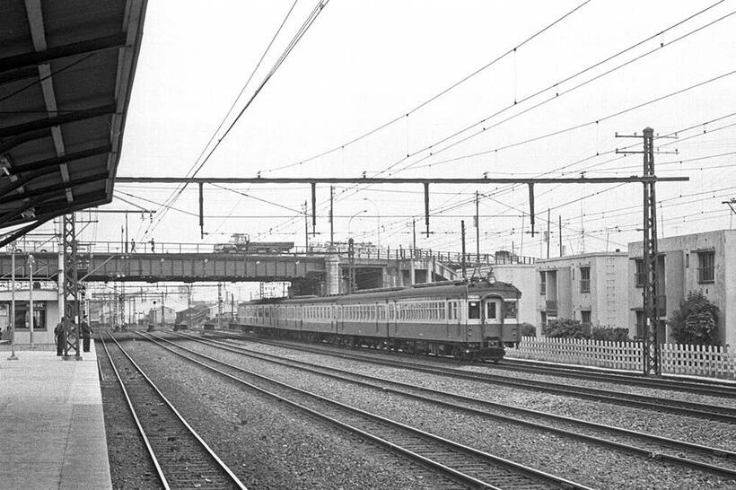 相模鉄道本線西横浜駅ホームから撮影した国鉄横須賀線下り電車。クモハ43型を先頭にする国電ファン憧れの編成が眼前を快走した。9系統の市電が走る尾張屋橋上には1963年式いすゞTXD50型6トン積トラックが写っている。（撮影／諸河久：1963年10月20日）