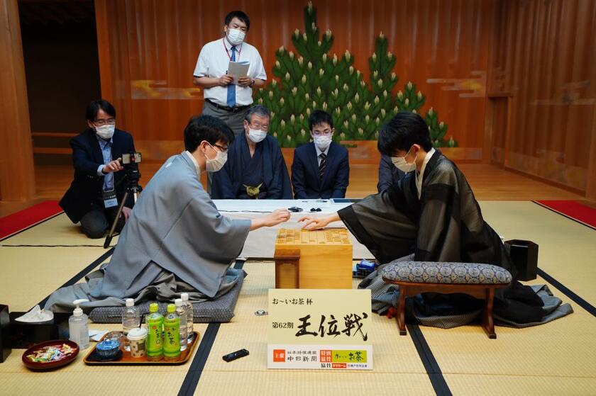 王位戦第１局を終え、感想戦を行う藤井聡太王位（手前右）と豊島将之竜王（同左）。日本将棋連盟提供