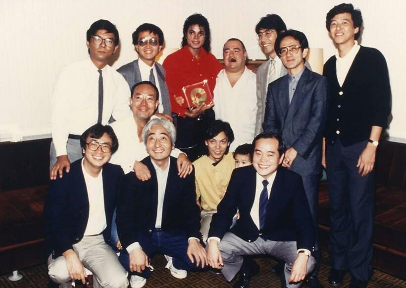 ウエルカム・パーティーにて当時のエピック・ソニー社員らと。マイケルの左隣が田中さん。右隣はマネージャーのフランク・ディレオ。マイケルの足もと、かがんでいる黄色いシャツの男性が清水さん（田中章さん提供）