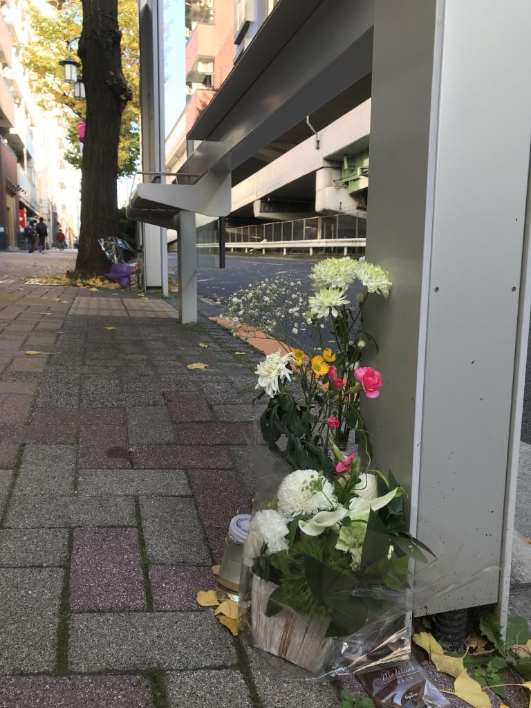 大林三佐子さんが殺害された東京都渋谷区のバス停に置かれた花束や飲み物。容疑者が逮捕された21日、お供え物が多くなっていた（撮影／編集部・渡辺豪）