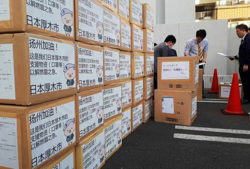 各地で支援の動きが始まっている。神奈川県内の自治体から、中国・揚州市へ向けて発送されるマスクや防護服などの支援物資。１箱ずつ「揚州頑張れ！」などを意味する中国語のメッセージが貼られた　（ｃ）朝日新聞社