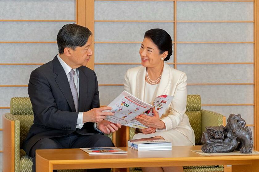 沖縄県で開かれた国民文化祭などの公式ガイドブックを見ながら天皇陛下と言葉を交わす皇后さま