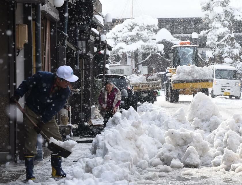 大雪が降り雪かきに追われる住民＝２０２２年１２月２４日午前、岐阜県