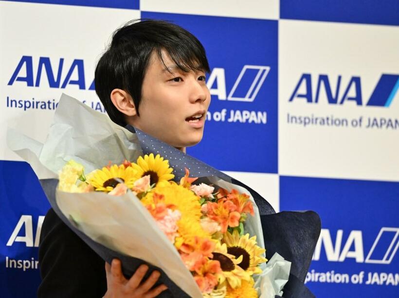 7月19日、「プロ転向」を表明した記者会見で花束を受け取る羽生結弦