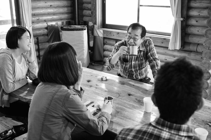 奥多摩のコテージで動物調査の参加者らと団欒のひととき。メンバーは20~40代の若い世代が多い。「いずれは彼ら一人ひとりが子どもに自然の楽しみ方を伝えられるようになってほしい」(今泉)(撮影/馬場岳人)