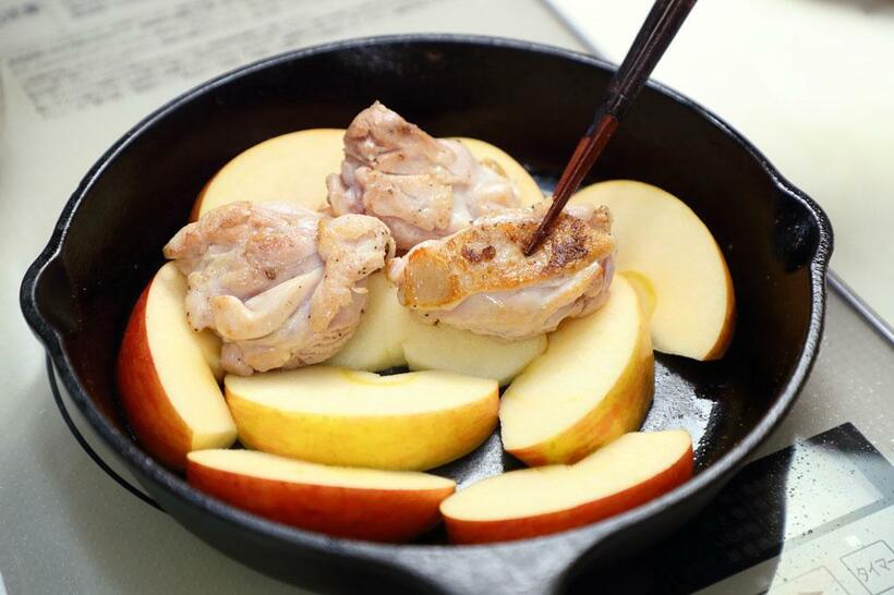 【ワンポイントアドバイス】鶏もも肉はりんごの上に並べ、肉が白ワインの蒸気でゆっくり蒸されていくようにする。　（撮影／写真部・松永卓也）
