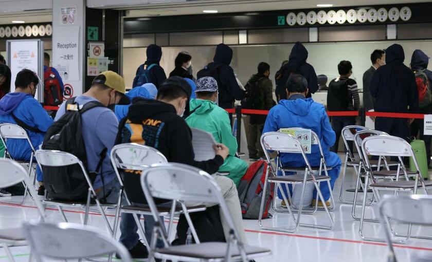 成田空港に到着し、検疫で特定の国での滞在歴の有無などの確認を受ける人たち