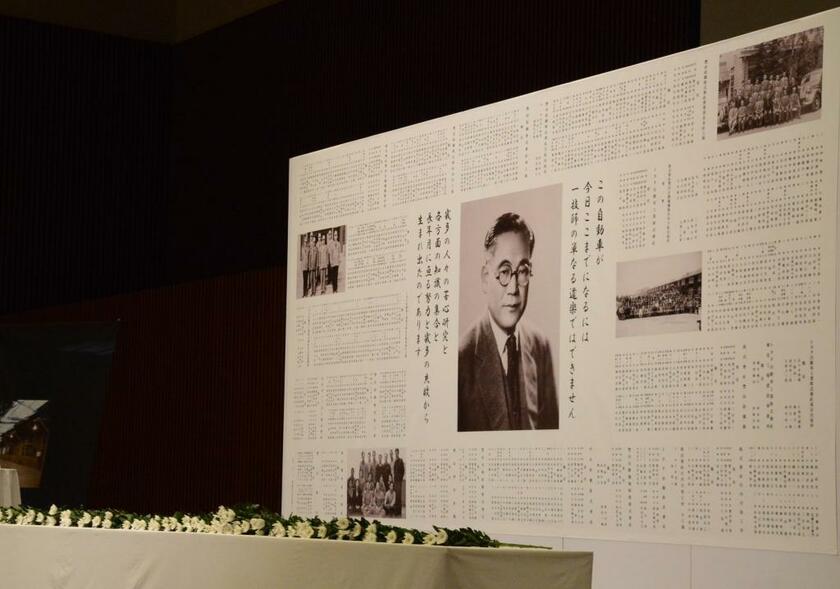 記念式典の壇上に掲げられたパネルには、豊田喜一郎の写真と当時のグループ企業で働いていた847人の名簿が載せられていた（トヨタ自動車提供）