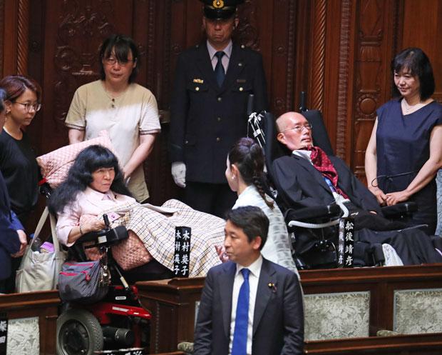 8月1日、参院本会議場に入り、ほかの議員からあいさつされる舩後靖彦さんと木村英子さん (c)朝日新聞社