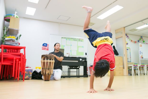 ブラジルの武術「カポエイラ」の基本動作を学ぶ子どもたち。専門の日本人講師がたたく太鼓のリズムに合わせ、体を動かす。こちらも本格的だ　（ｃ）朝日新聞社