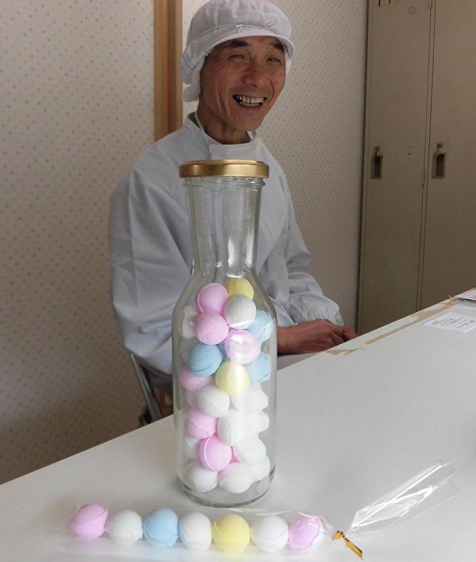 イコマ製菓本舗の平口治社長と「レインボーラムネ」=撮影・粟野仁雄