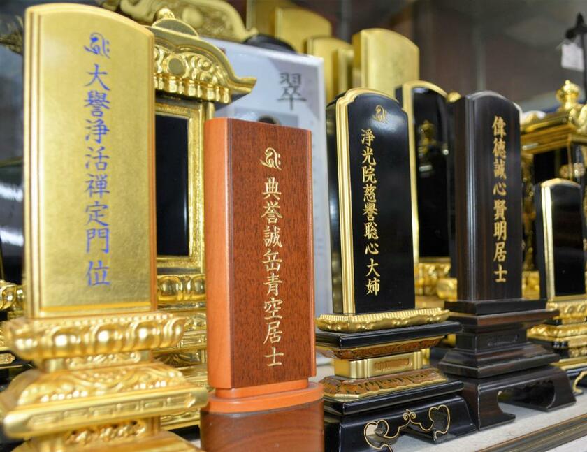 仏壇店に並ぶ位牌。戒名の見本が刻まれている　（ｃ）朝日新聞社