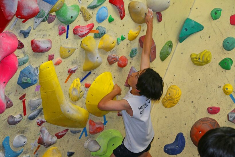 千葉県立幕張総合高校に設置されたスポーツクライミングのボルダリング競技の壁を登る生徒＝千葉市、米倉昭仁撮影