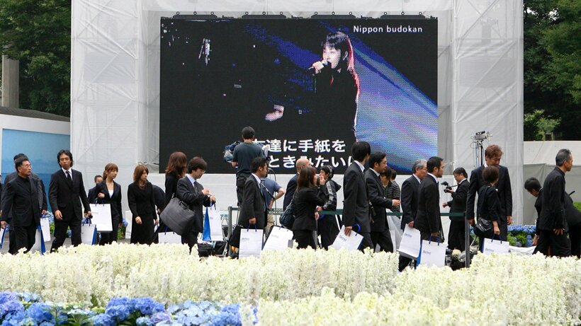 大型画面にZARDの坂井泉水さんの姿が流れる中、献花に訪れた会葬者たち＝2007年6月26日