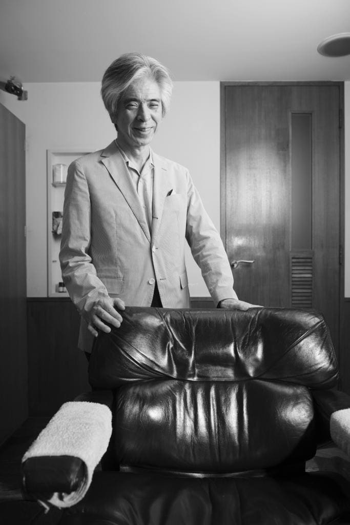 サロン「ＯＨＢＡ」本店で、徳仁天皇も座った椅子を前に、撮影に応じる大場隆吉さん。東宮御所の改修中は、サロンの個室で調髪した