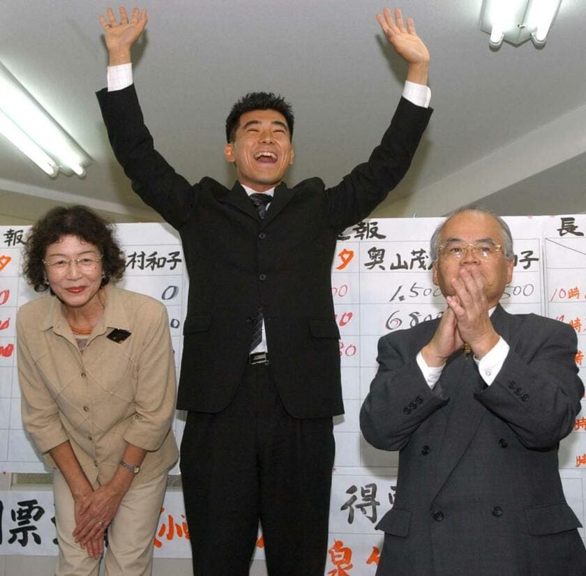 初当選を決めて万歳する泉健太氏。左は母親の博子さん／2003年11月9日、京都市伏見区