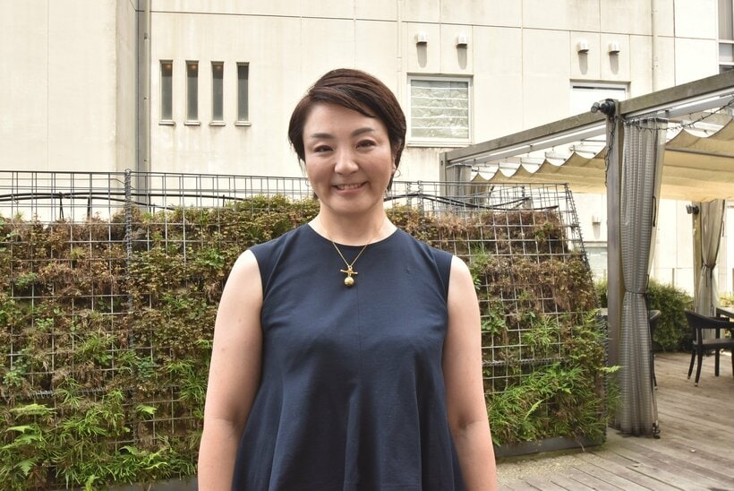 取材の待ち合わせ場所に紺色のノースリーブのツーピースで現れた河井あんりさん。有罪判決の確定後は外出できず、家族が買ってきたケーキを食べ続けた結果、4年間で20キロも太ったという。レストランではトンカツを選び、「共食い」と言って笑った＝2025年7月、東京都内、大崎百紀撮影