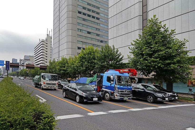 画面右側から中央が世田谷区代田に移転した聖三一教会の跡地に建つ青山ツインビル（新青山ビル）。1973年に建て替えられた赤坂郵便局舎が、道路を隔てて隣接している。　青山一丁目（撮影／諸河久：2019年7月13日）