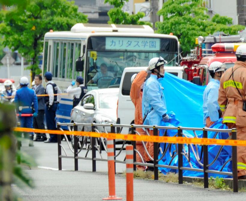 事件直後にスクールバス付近を調べる警察官や救急隊員（ｃ）朝日新聞社