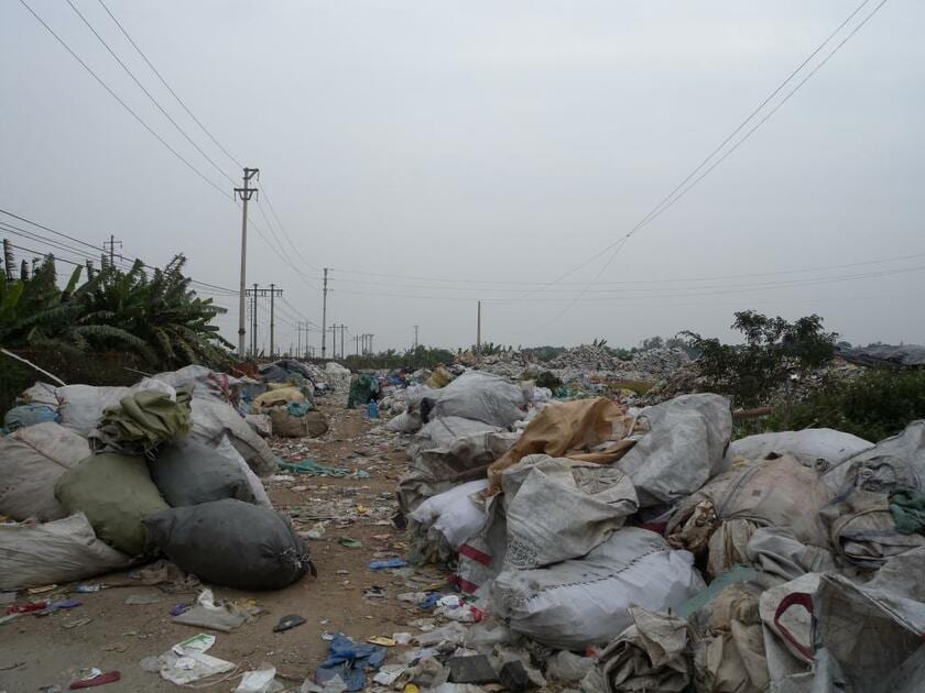 廃プラスチックのリサイクルが盛んなベトナム・フンイエン省のミン・カイ村。大量の廃プラスチックが散乱したまま放置されていた／２０１１年１月（写真：小島道一さん提供）