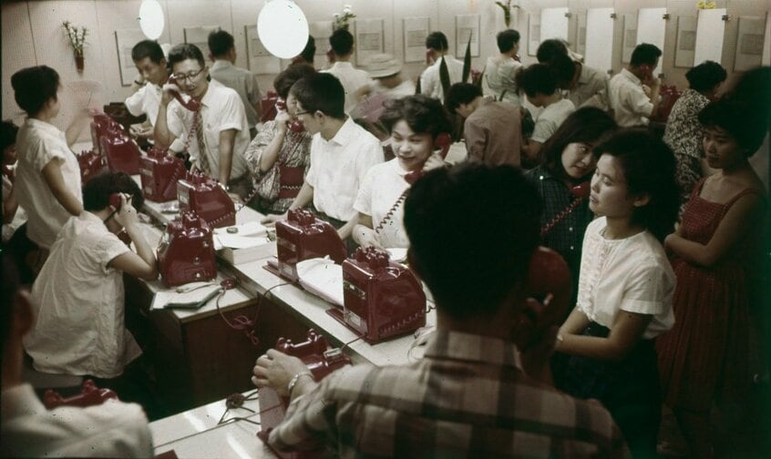 1961(昭和36)年9月、渋谷駅で撮影。打ち合わせや約束をする人々で駅の赤電話は常に埋まっていた