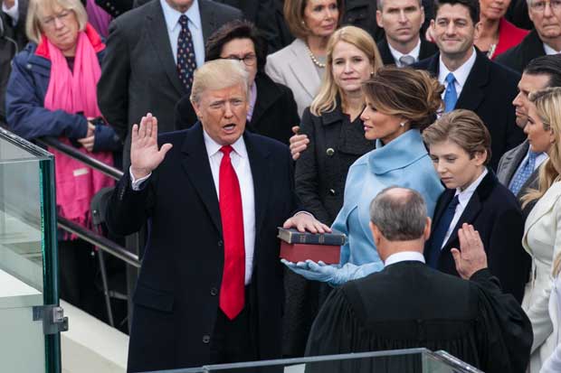 トランプ大統領は１月２０日の就任式で、左手を聖書に置き、右手を挙げて恒例の宣誓をした。トランプ時代が幕を開けた瞬間だ　（ｃ）朝日新聞社