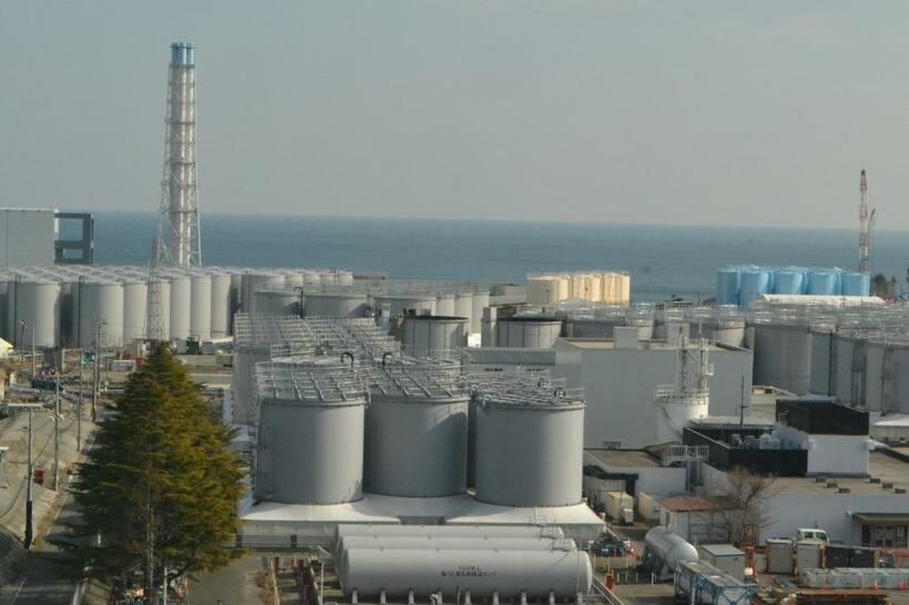 「処理水」が入ったタンクが林立する。奥の左端には４号機の建屋が見える。その先にあるのは太平洋だ（代表撮影）