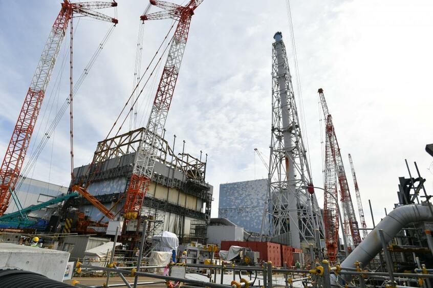 がれき撤去作業中の1号機の原子炉建屋(左)。2号機(右)では2月、核燃料(デブリ)と見られる物体に初めて触れた/2019年2月15日、福島県大熊町で (c)朝日新聞社