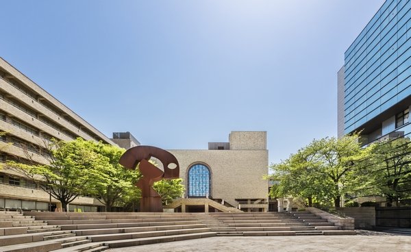 ステンドグラスが印象的な川並香順記念講堂を正面に、左が７号館、右が８号館。中央のオブジェは彫刻家・流政之の作品「PACHI PACHI」