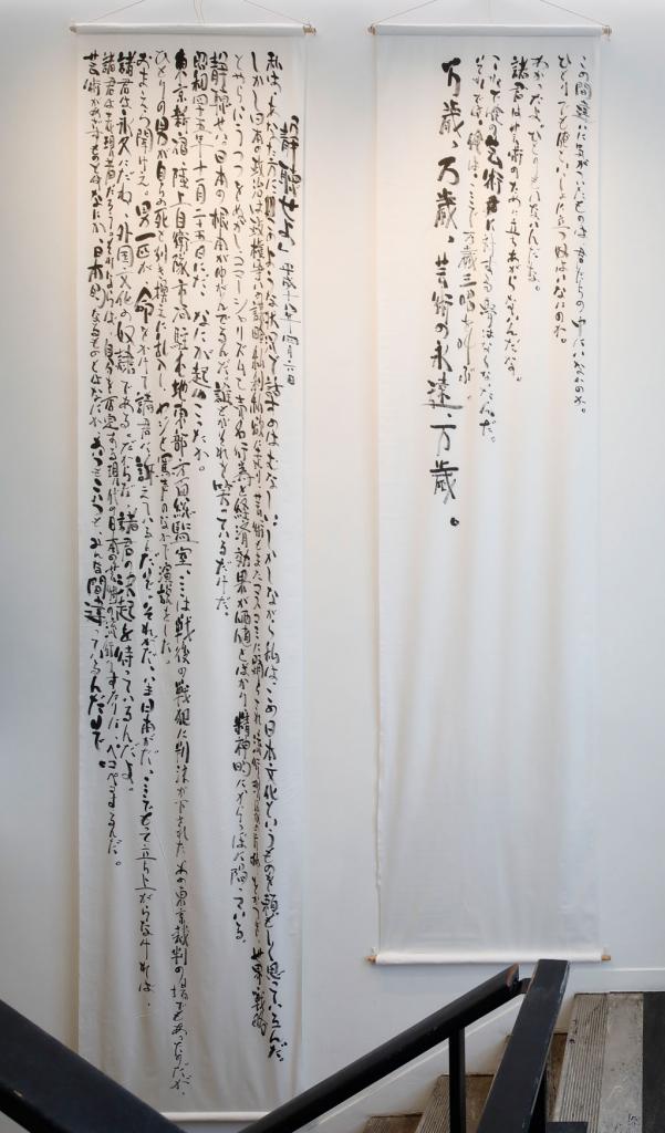 布地に墨で森村さんが書いた「マニフェスト（烈火の季節）」。会場にはさまざまな言葉も展示されている（撮影／木奥惠三）