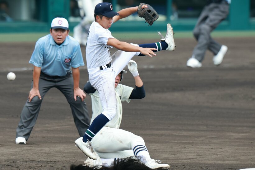 【決勝】四回裏、頭上高くに飛んだ二塁悪送球に飛びついた沖縄尚学・真喜志。走者・竹中（撮影／写真映像部・東川哲也）