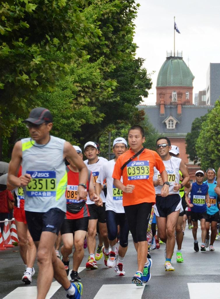北海道庁赤れんが庁舎を背に走る「北海道マラソン」出場者ら。国内唯一の日本陸連公認の本格的な夏季大会で、今年は１万３４５７人が完走した／２０１３年８月、札幌市中央区　（ｃ）朝日新聞社