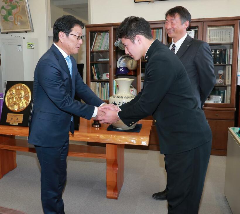 栗山監督と握手する吉田。甲子園のときよりかなり体の厚みが増している　（ｃ）朝日新聞社
<br />
