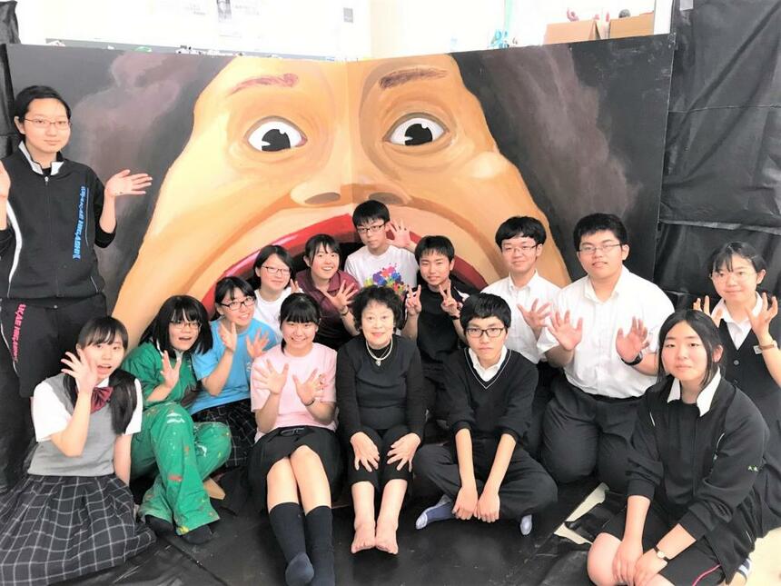 文化祭にて、美術部作製「校長のトリックアート」の前で生徒たちと。中央が田中淳子校長（写真は提供）