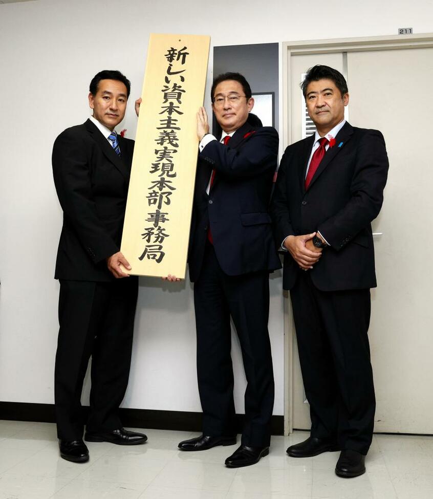 「新しい資本主義実現本部事務局」の看板を掲げる(左から)山際大志郎経済再生相、岸田首相、木原内閣官房副長官