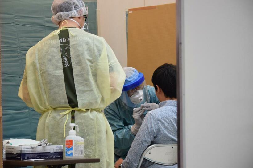 ＰＣＲ検査の未実施が感染拡大の大きなリスクになっている。４月３日、成田空港の検疫検査場の仮設ブースで、ＰＣＲ検査のため検体を採取しているところ　（ｃ）朝日新聞社