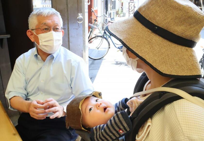 兵庫県明石市の泉房穂市長（左）。商店街で子育て中の市民らから声を掛けられることも