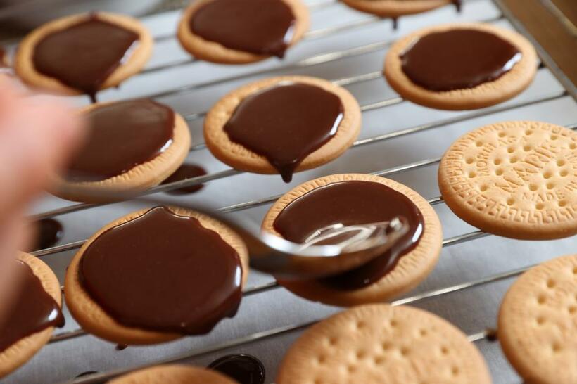 紙を敷き、脚付きのアミ上でクッキーにチョコレートをのせるとやりやすい。（撮影／写真映像部・松永卓也）