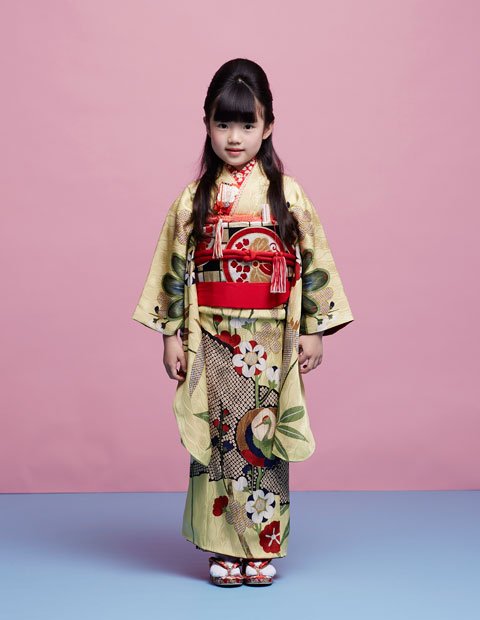 灯り屋２／立涌模様の綸子地に松竹梅、抱え鶴を配したクリームイエローの７歳祝着。重厚感のある丸帯を赤の小物で引き締めて。コーディネート一式レンタル料８００００円（Photo／YUMIKO TARUKI［TRON］）