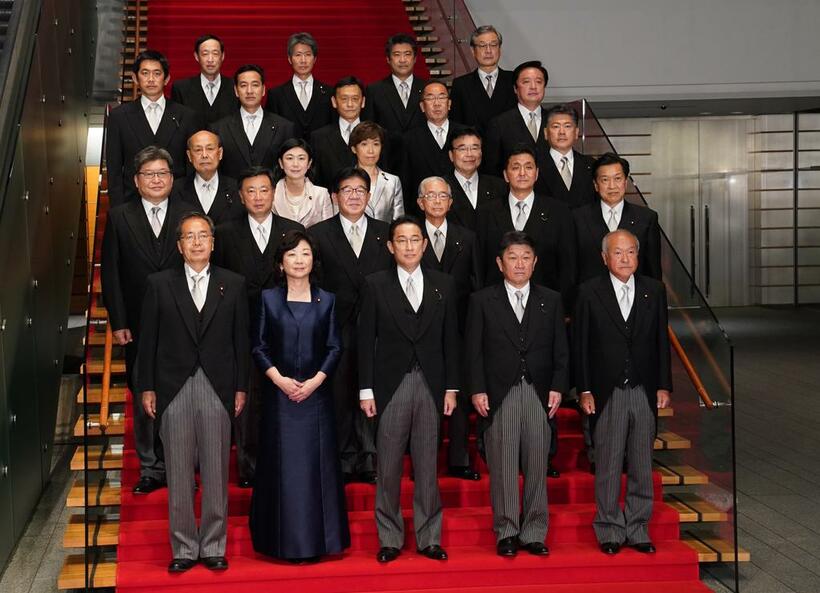 自民党の岸田文雄総裁（前列真ん中）は首相に指名され、新内閣が発足。これまで通り夜には、首相官邸の赤い大階段で閣僚たちがそろって記念撮影におさまった。ドレスコードは、男性閣僚が「モーニングコート」、女性閣僚が「ロングドレス」とされている＝１０月４日、首相官邸で　（ｃ）朝日新聞社
