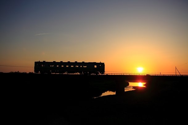 夕陽をバックに走る江差線の列車その他の写真はフォトギャラリーで