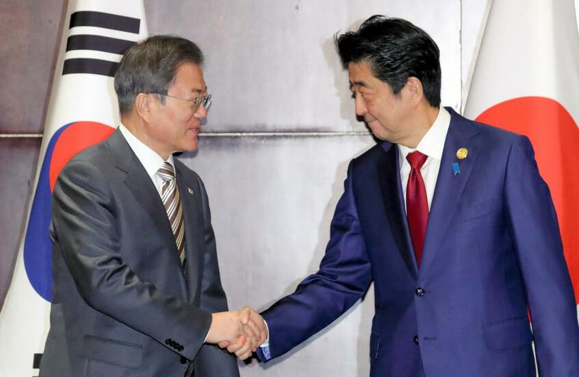 首脳会談冒頭、韓国の文在寅大統領(左)と安倍晋三首相は笑みを浮かべながら握手を交わした/2019年12月24日、中国・成都で (c)朝日新聞社