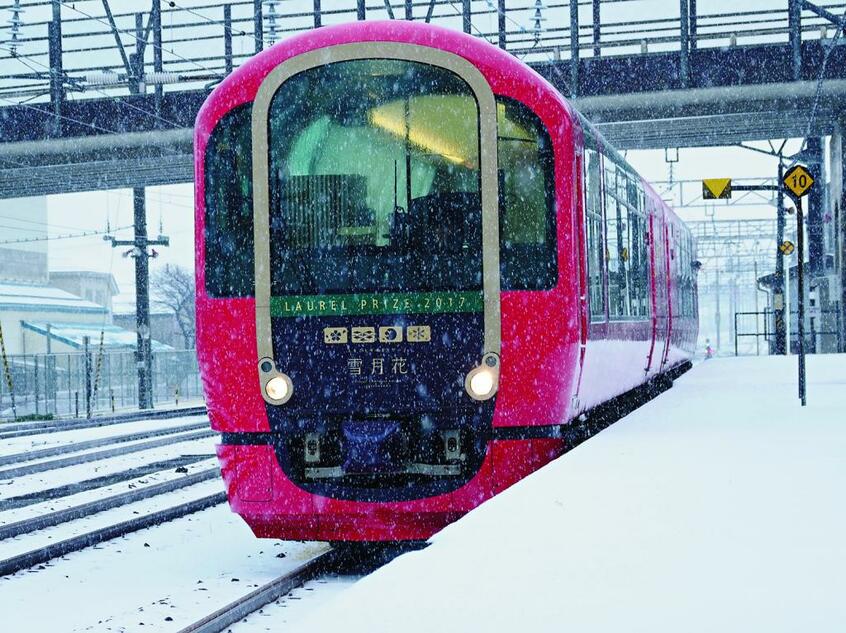 しんしんと雪降りつのる糸魚川駅に「雪月花」が入線する。あたかもモノクローム写真のような白と黒のみの雪景色の中を、銀朱色もあでやかな「雪月花」が近づいてきた。大らかな丸味を帯びた車体、なんて美しい列車なのだろう。まぎれもない新潟美人であり一目ぼれしてしまう。なお、2017年には鉄道友の会による「ローレル賞」に輝いた
<br />■オリンパスOM-D E-M1 MarkII・12~100ミリF4・絞りf5・AE・ISO6400・JPEGスーパーファイン(撮影/櫻井寛)