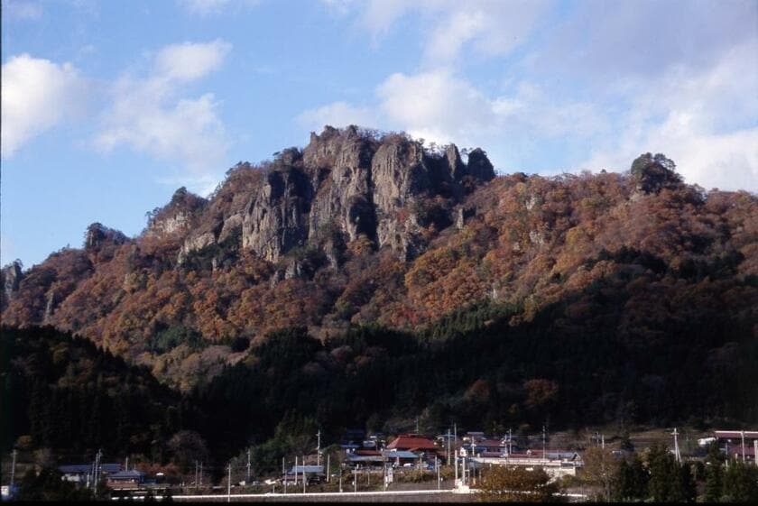 岩櫃城がある岩櫃山の遠景／岩櫃城は岩櫃山の北東に延びる尾根に位置する。東は吾妻川、西は岩櫃山、南は吾妻川へ下る急斜面、北は岩山という要害。