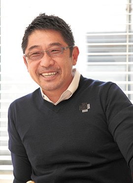 「世界中で自宅が一番くつろげる」と金子さん。金子さんが背にするリビングの大きな窓からは、庭が一望できる。東京生まれだが、横浜が気に入って、この家に住む前にも10年間、同じ街のマンションで暮らしていた。