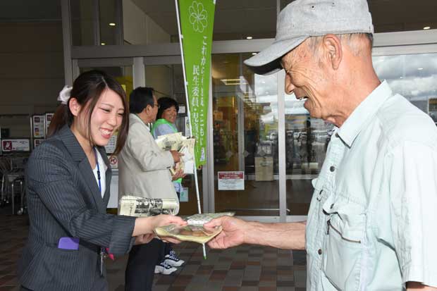 制度１００年になる民生委員制度を紹介するチラシを配るスタッフ　（ｃ）朝日新聞社