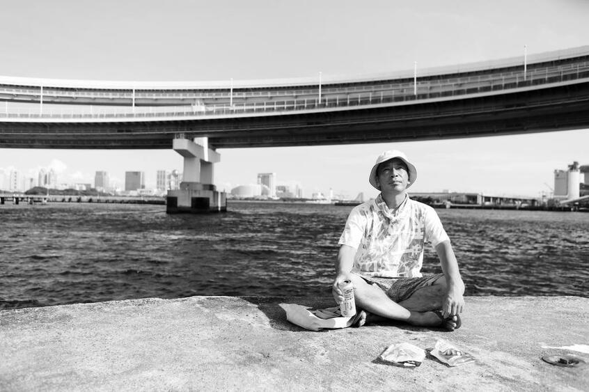 隠れ家のようにしている波止場で、潮風に吹かれながら缶ビールを片手にボーッとする。金などかけなくても、暮らしを豊かにする方法を岡はたくさん知っている(撮影/加藤夏子)