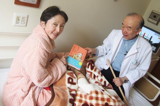 病室で過ごすおだやかな時間に、気に入った本を読む患者さん (野の花診療所提供)