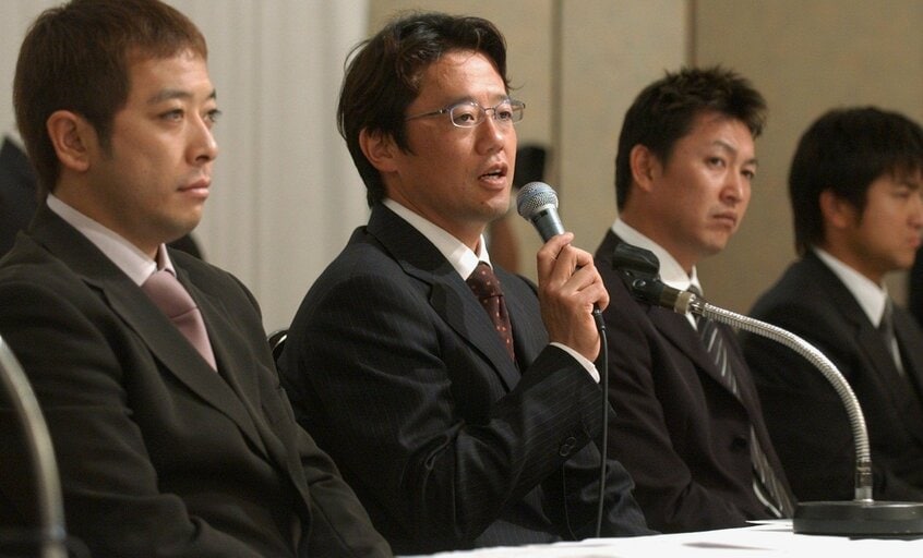 2004年9月、ストライキを設定し記者会見する日本プロ野球選手会会長(当時)の古田氏(中央)