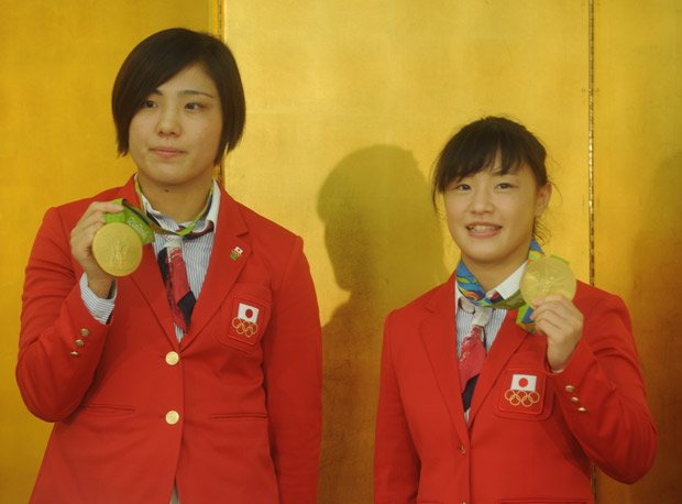 笑顔で金メダルを披露する田知本（左）、登坂選手